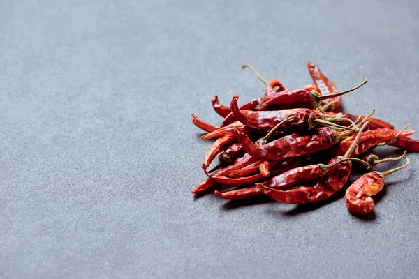 Nahaufnahme würziger Chilischoten auf grauer Tischplatte — Stockfoto