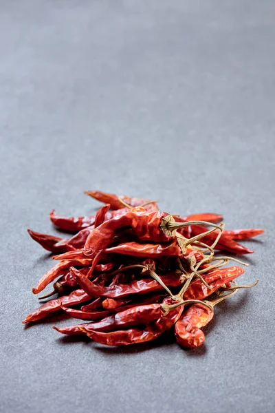 Close up view of pile of red chili peppers on grey surface — Stock Photo