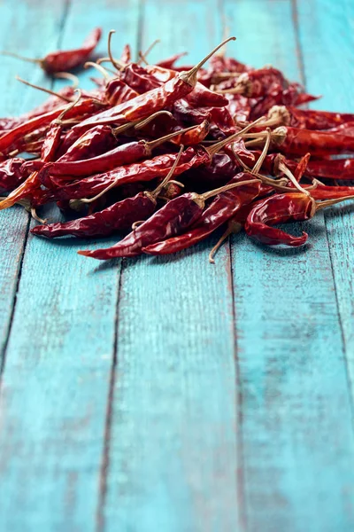 Close up view of red dried chili peppers on blue wooden surface — Stock Photo