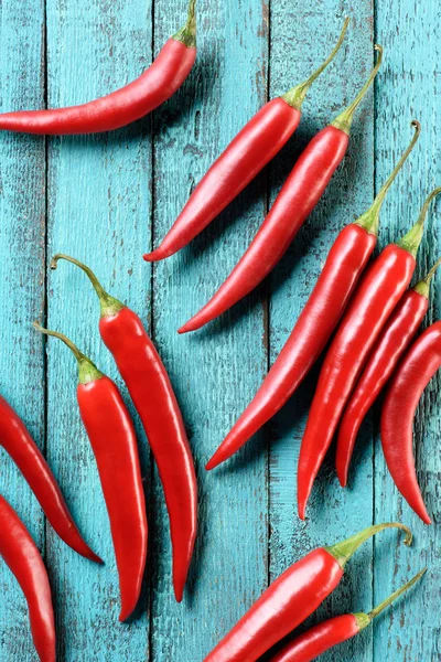Вид сверху на красный вкусный перец чили на голубой деревянный стол — Stock Photo