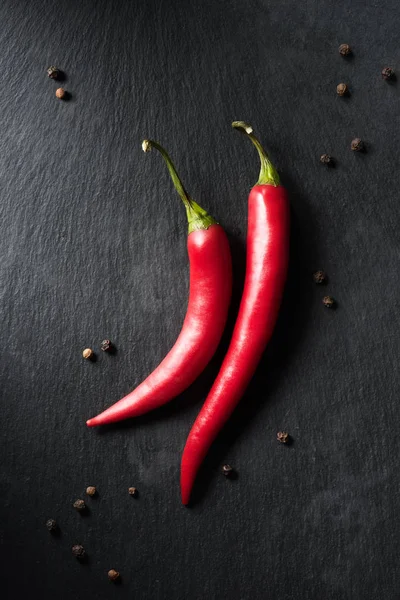 Vue de dessus de deux piments mûrs sur la surface noire — Photo de stock