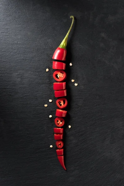 Vista superior de pimenta vermelha picada cortada na superfície preta — Fotografia de Stock