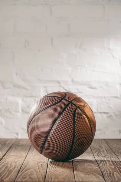 One brown basketball ball on wooden floor — Stock Photo