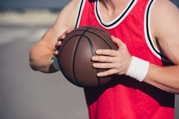 Cropped image of sportsman playing basketball on street — Stock Photo