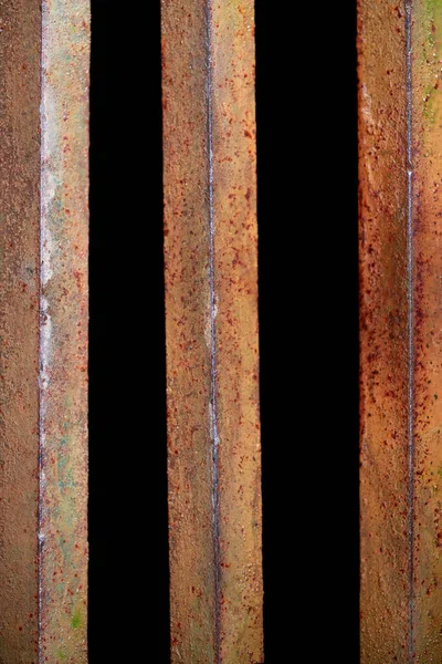 Close up view of rust fence with black background behind — Stock Photo