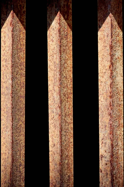 Close up view of rust fence with black background behind — Stock Photo