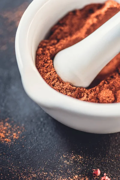 Vue rapprochée de bol blanc avec poudre de chili séché aromatique sur noir — Photo de stock