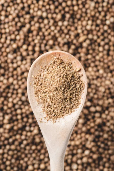 Top view of wooden spoon with coriander powder and seeds — Stock Photo