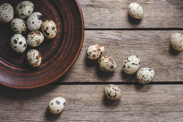 Top view of healthy raw quail eggs on plate on wooden table — Stock Photo