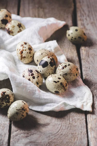 Vue rapprochée d'oeufs de caille sains et de tissu sur une table en bois rustique — Photo de stock