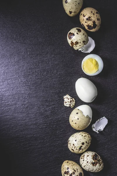 Top view of healthy cooked quail eggs on black background — Stock Photo