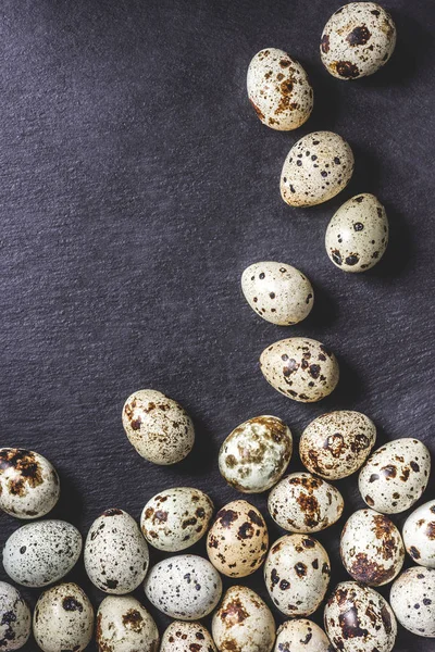 Top view of organic unshelled quail eggs on black background — Stock Photo