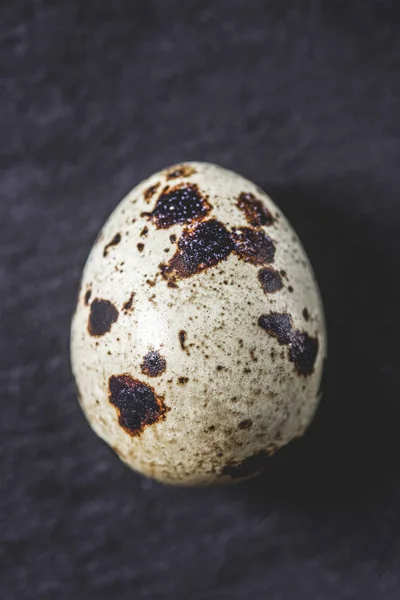 Top view of organic unshelled quail egg on black, close-up view — Stock Photo