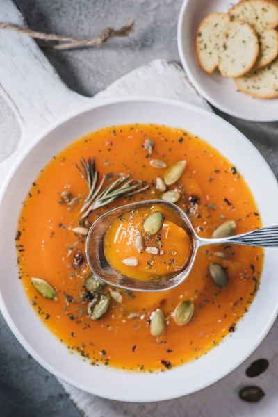 Top view of spoon over plate with pumpkin cream soup on table — Stock Photo