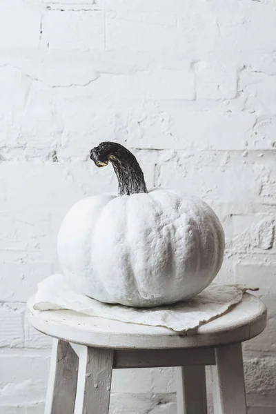 Close-up shot of white painted halloween pumpkin in front of white brick wall — Stock Photo