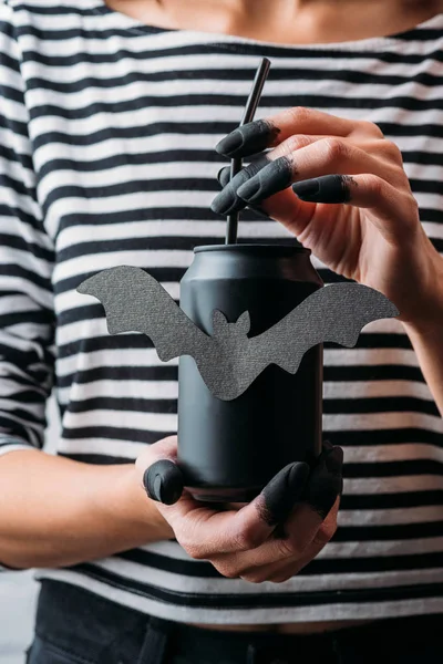 Cropped shot of woman holding black can of soda with bat sticker, halloween concept — Stock Photo