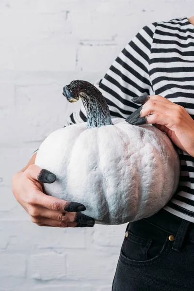 Tiro cortado de mulher segurando branco pintado abóbora halloween — Fotografia de Stock