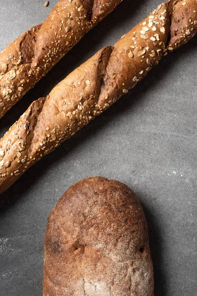 Vista superior de baguetes e pão na superfície cinzenta — Fotografia de Stock