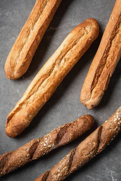 Quadro completo de loafs arranjados de baguetes em mesa cinza — Fotografia de Stock