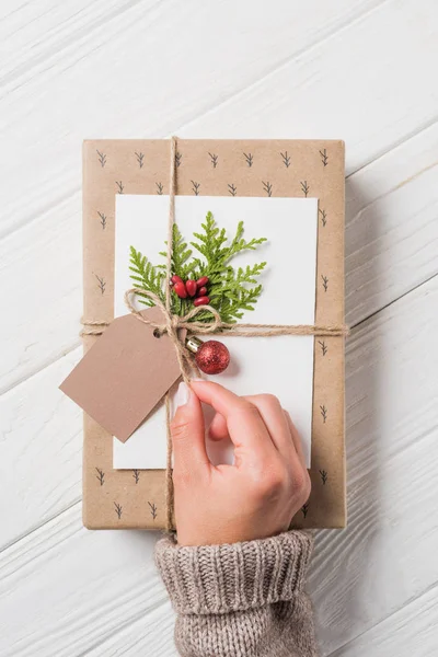 Partial view of woman decorating christmas gift box at wooden table — Stock Photo