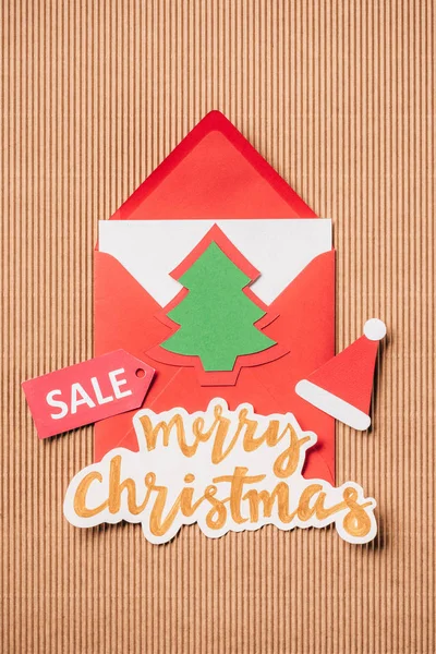 Elevated view of greeting envelope, lettering sale and merry christmas on surface — Stock Photo