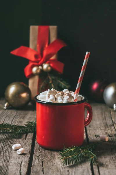 Cup of hot cocoa with marshmallows on wooden table with fir tree at christmastime — Stock Photo