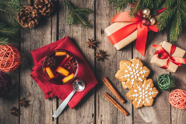 Vista superior de vidrio con vino caliente con especias con pan de jengibre, abeto y cajas de regalo - foto de stock