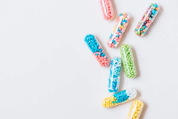 Vue de dessus de différentes capsules médicales colorées sur la surface blanche — Photo de stock