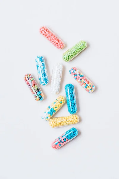 Vista dall'alto di diverse capsule mediche colorate su bianco — Foto stock