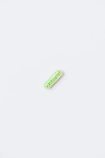 Draufsicht auf grüne medizinische Kapsel auf weiß — Stockfoto