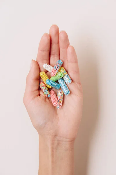 Ritagliato colpo di donna in possesso di varie capsule mediche colorate su bianco — Foto stock