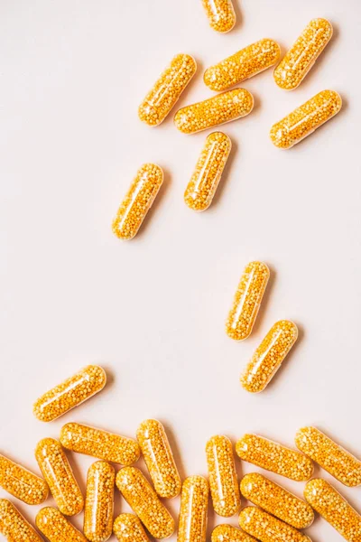 Vue du dessus des capsules médicales jaunes sur blanc — Photo de stock