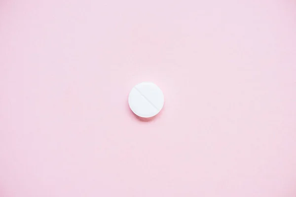 Top view of white medical pill on pink surface — Stock Photo