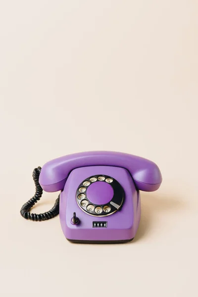 One purple vintage telephone on beige — Stock Photo