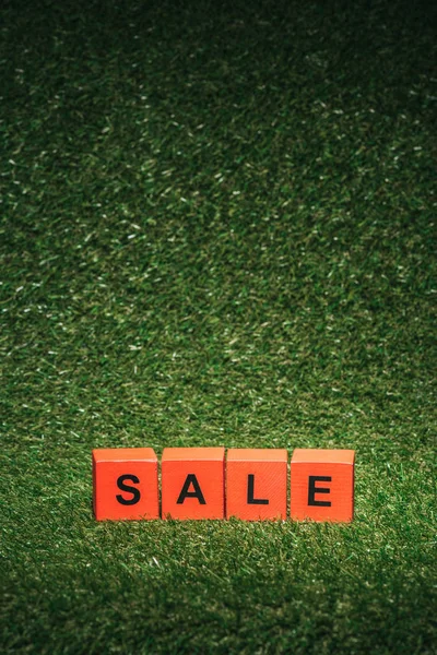 Bloques de alfabeto rojo con letrero de venta para el viernes negro sobre hierba verde - foto de stock