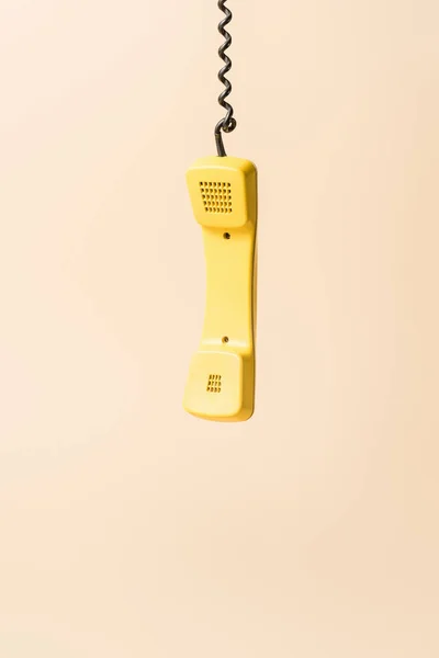 Tubo de telefone vintage amarelo no bege — Fotografia de Stock