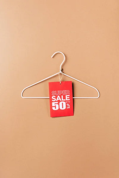 Hanger with red super sale tag with fifty percents discount on beige — Stock Photo