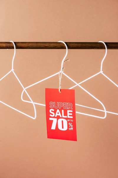 Hangers with red super sale tag - 70 percents discount on beige — Stock Photo
