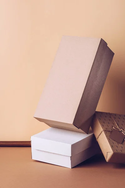 Boîtes à chaussures et cadeau sur beige en studio — Photo de stock