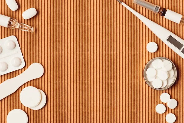 Flat lay of various medical tools and medicines on cardboard background — Stock Photo