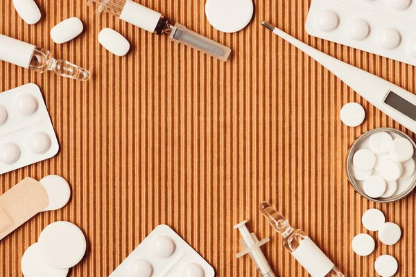 Vista dall'alto di vari strumenti medici e farmaci su sfondo di cartone — Foto stock