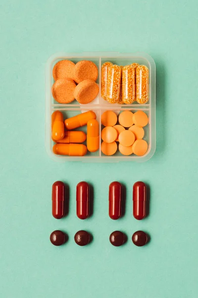 Top view of drugs in container, medical pills and capsules isolated on green — Stock Photo