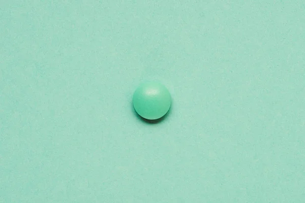 Top view of round green tablet on green background — Stock Photo