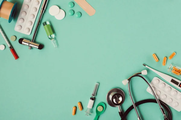 Вид различных медицинских таблеток и инструментов на зеленом фоне — стоковое фото