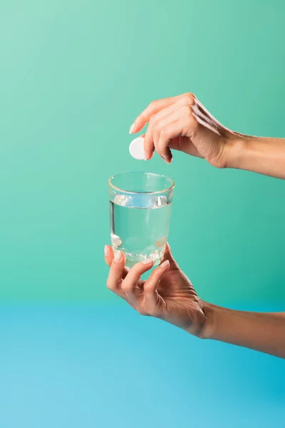 Plan recadré de la personne tenant verre d'eau et pilule isolé sur vert — Photo de stock