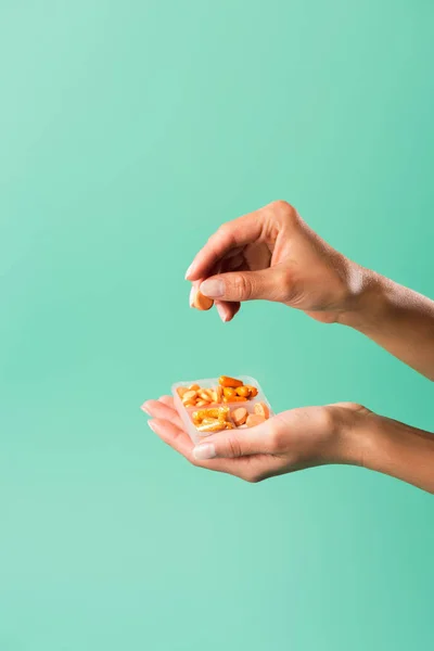 Copped shot of person holding container with colorful isolated on green — Stock Photo