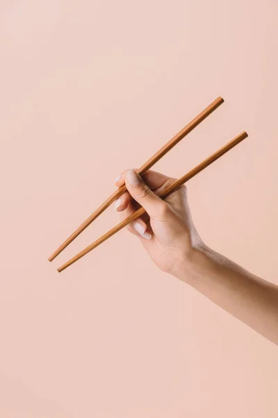 Corte tiro de mulher segurando pauzinhos isolados no bege — Fotografia de Stock