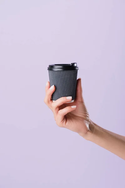 Abgeschnittene Aufnahme einer Frau, die eine Papptasse Kaffee hält, um sich auf lila zu isolieren — Stockfoto