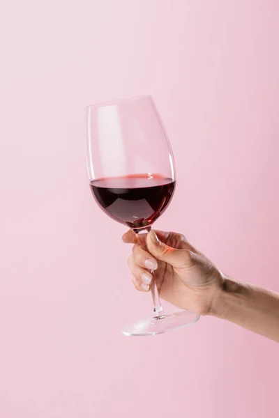 Colpo ritagliato di donna che tiene un bicchiere di vino rosso isolato su rosa — Foto stock