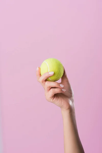 Tiro recortado de la mujer sosteniendo pelota de tenis aislado en rosa - foto de stock